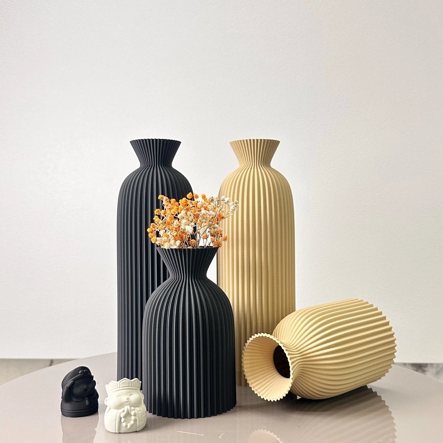 Set of black and beige vases on a light surface with a white background