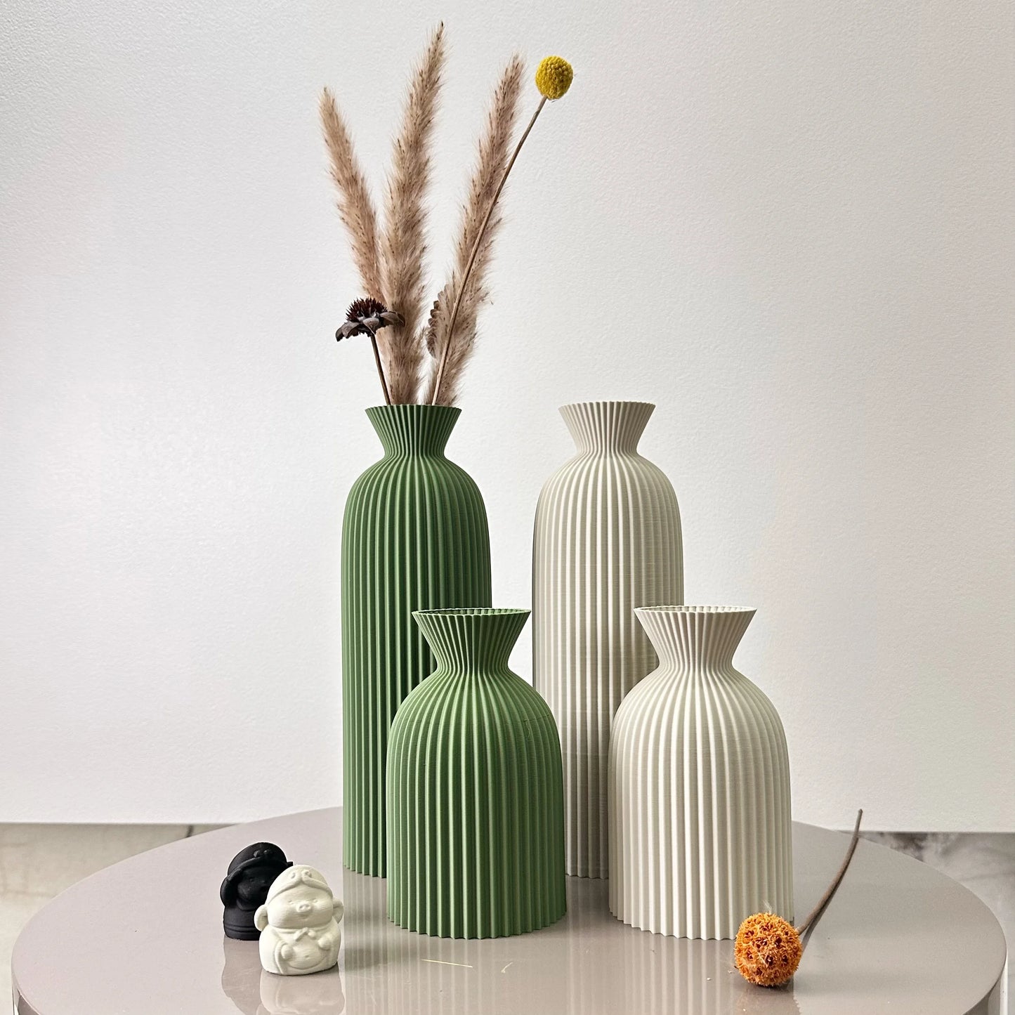 Set of four decorative vases on a table with a plain background