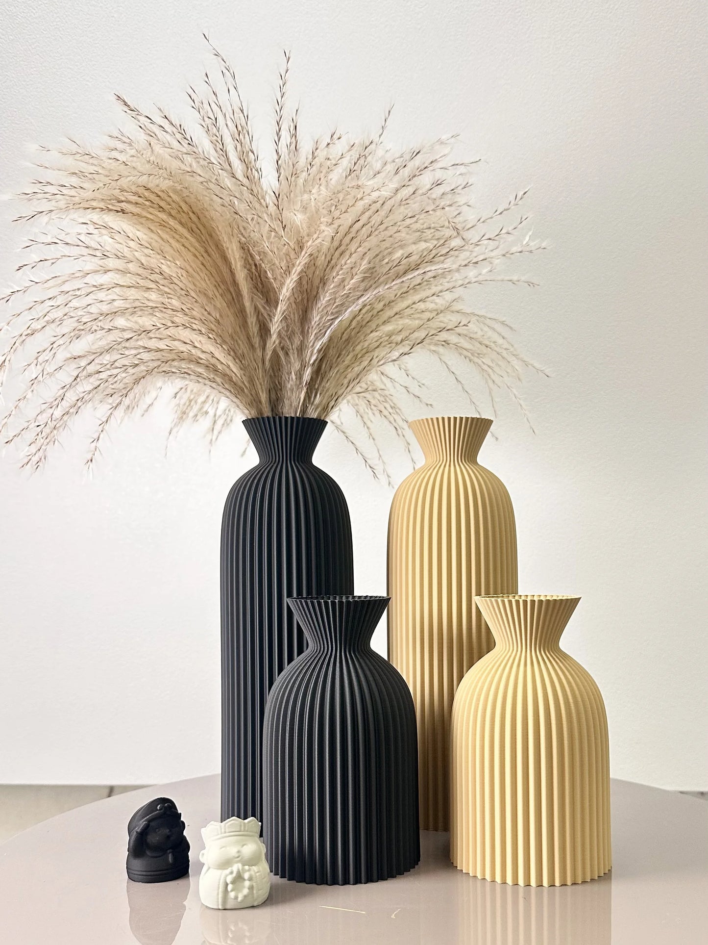 Set of four decorative vases with textured designs on a light surface.