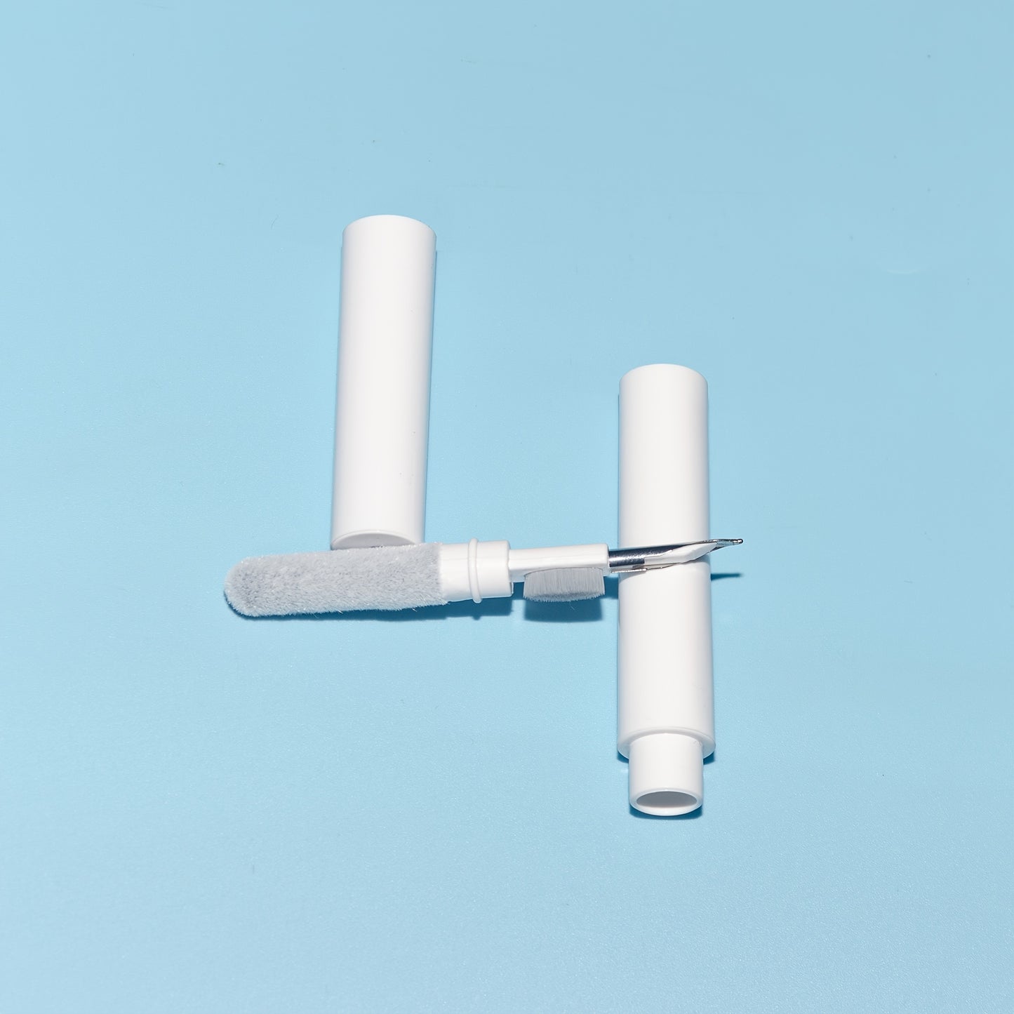 White cleaning tool with a brush and handle on a light blue background