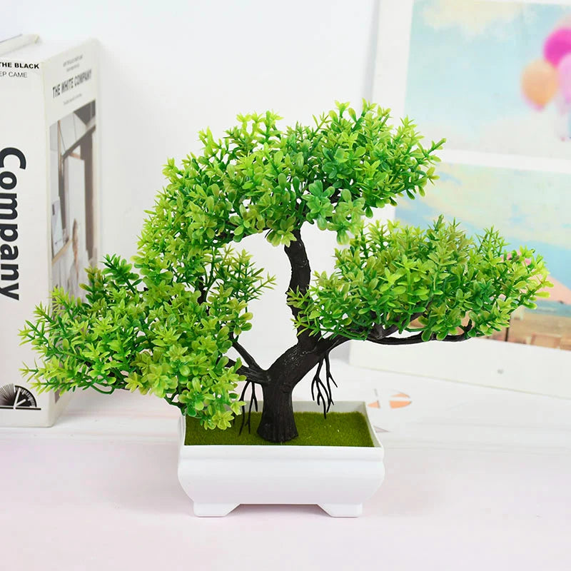 Artificial bonsai tree in a white pot on a light surface with a blurred background