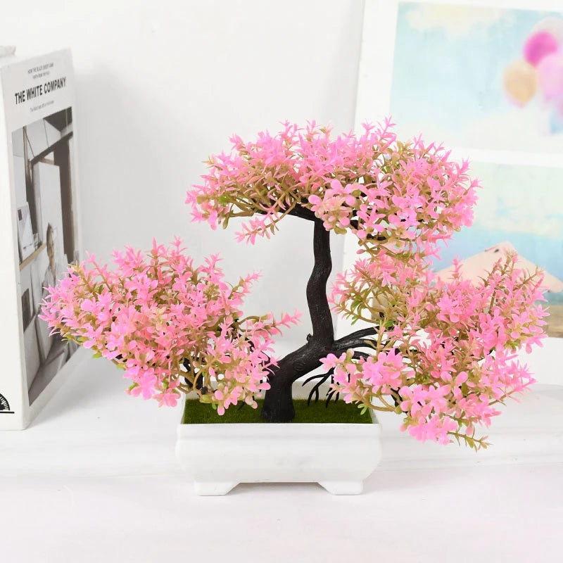 Artificial pink blossom tree in a white pot on a light background