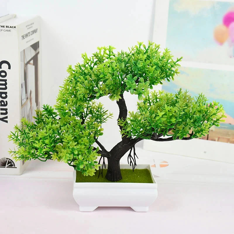 Small potted artificial tree on a white surface with a blurred background