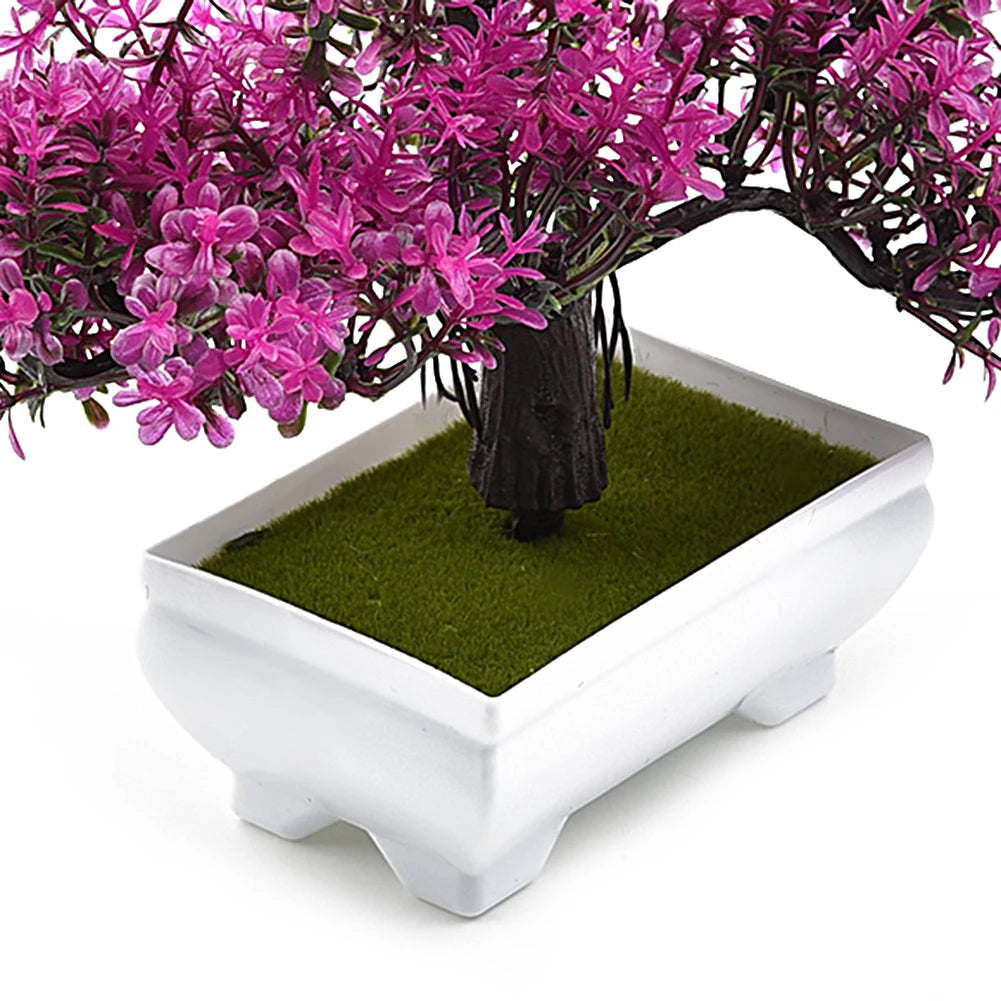Artificial bonsai tree with pink flowers in a white pot on a white background