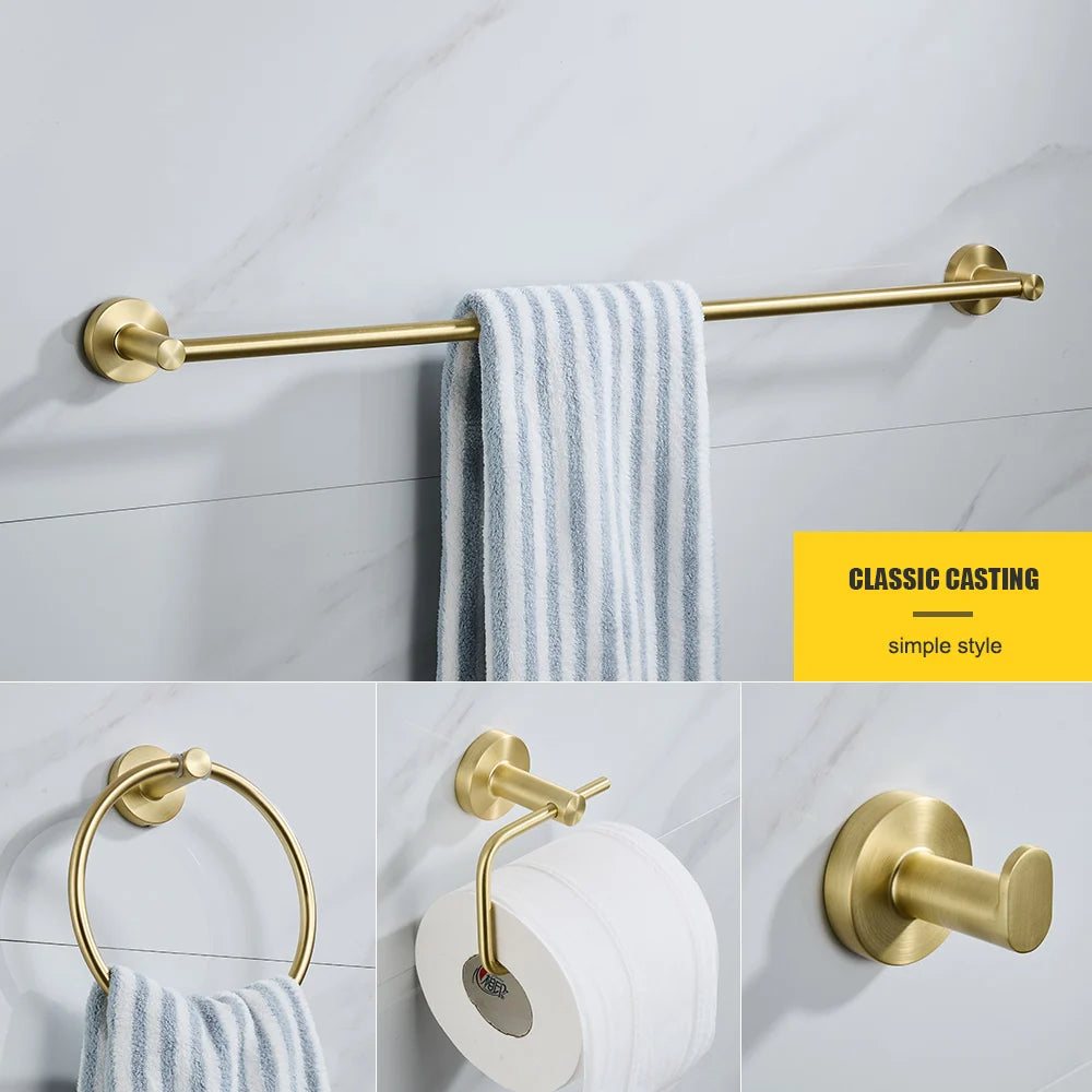 Gold bathroom hardware set including a towel bar, ring, holder, and hook on a tiled wall.