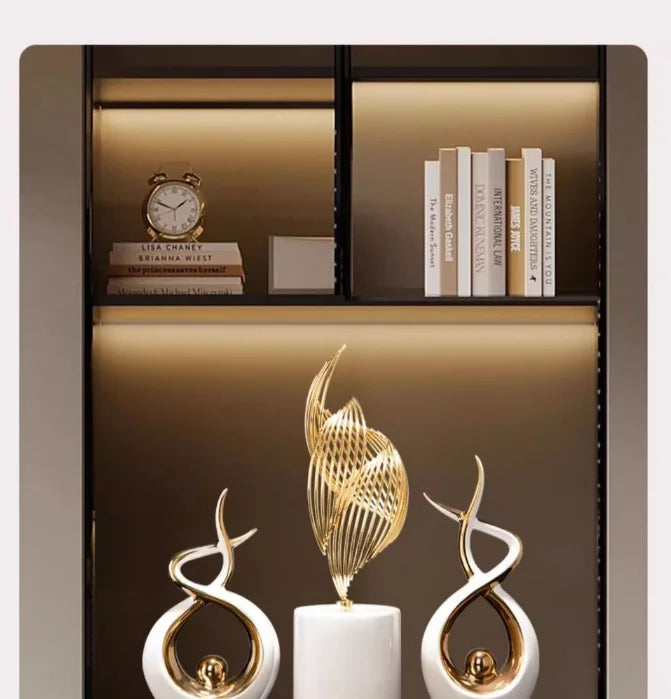 Decorative bookshelf with books and ornamental gold sculptures.
