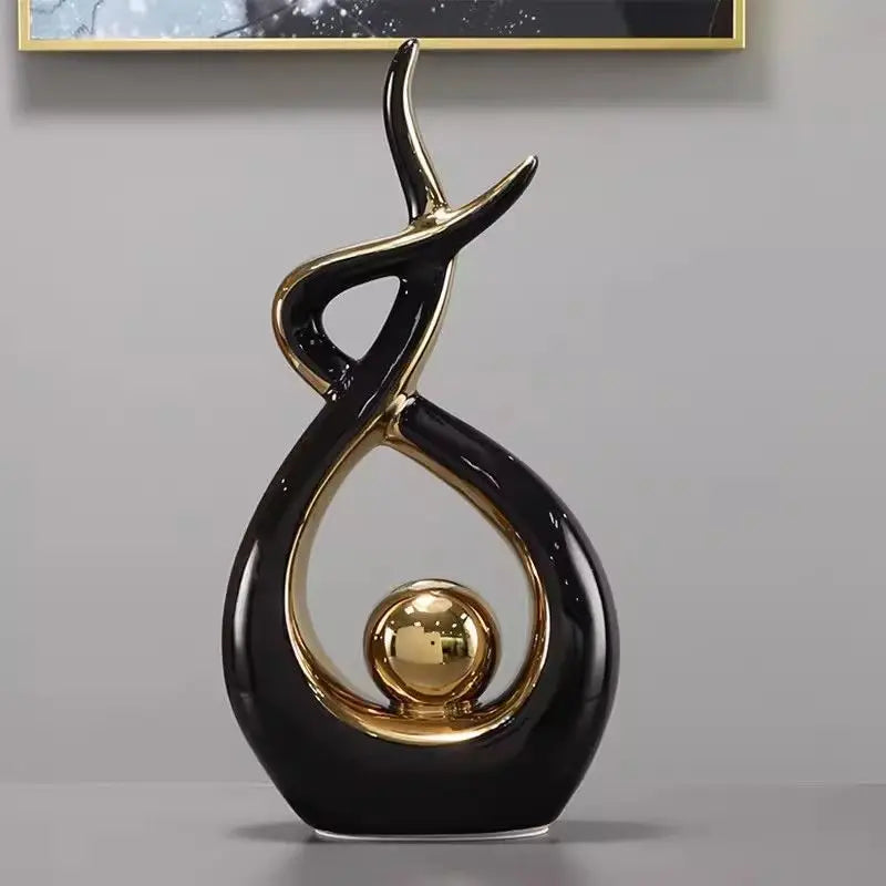 Decorative black and gold sculpture on a gray surface with a neutral background