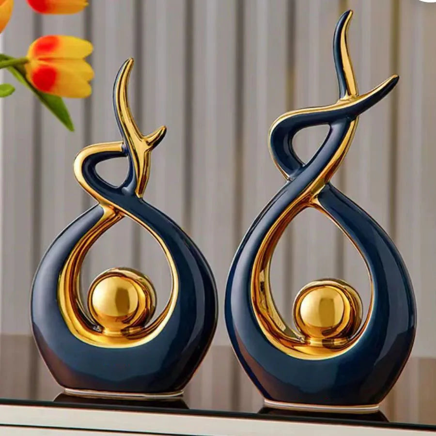 Two decorative vases with gold accents on a reflective surface.