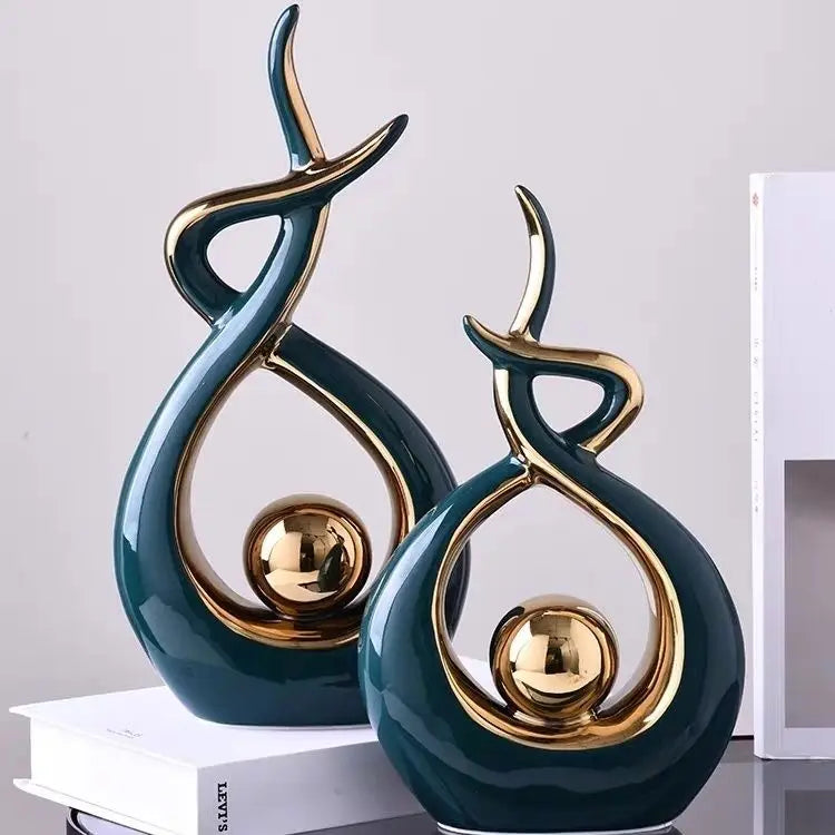 Two decorative sculptures with gold accents on a light gray background