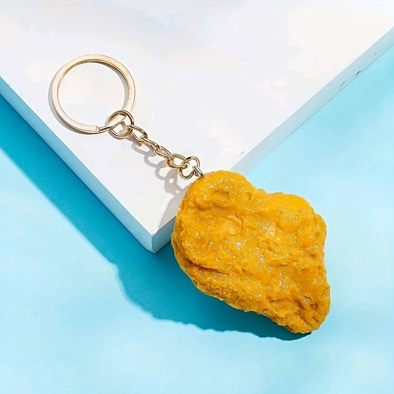 Yellow rock-shaped keychain on a light blue surface with a white box in the background