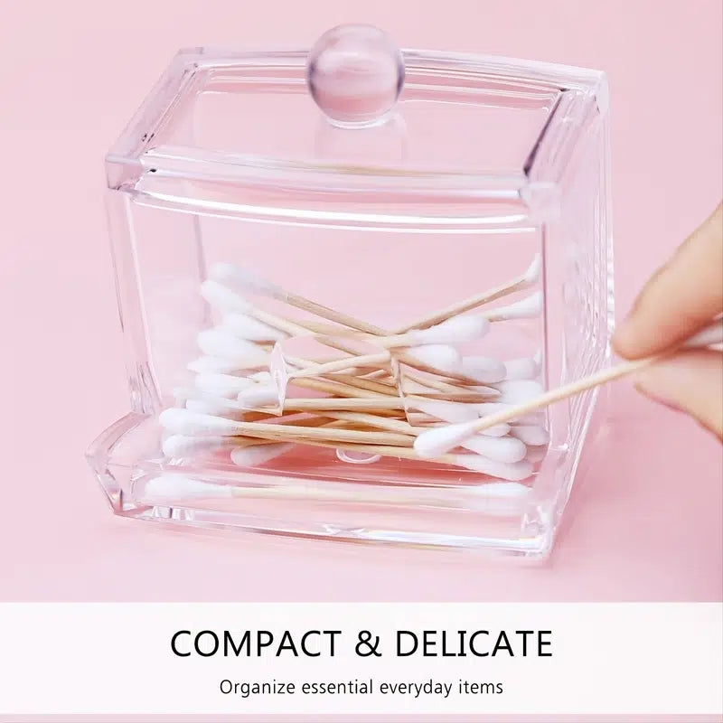 Clear glass container with cotton swabs on a pink background