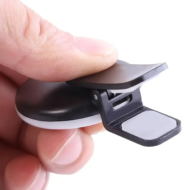 Black and white clip held between fingers on a white background