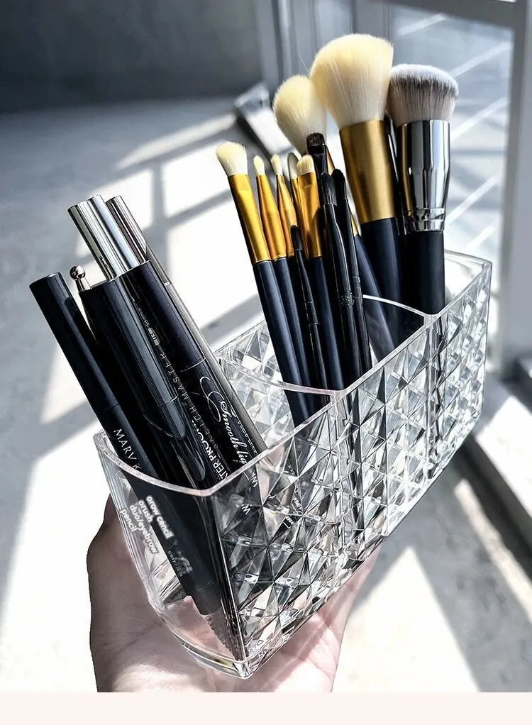 Clear acrylic makeup brush holder with various brushes and bottles.