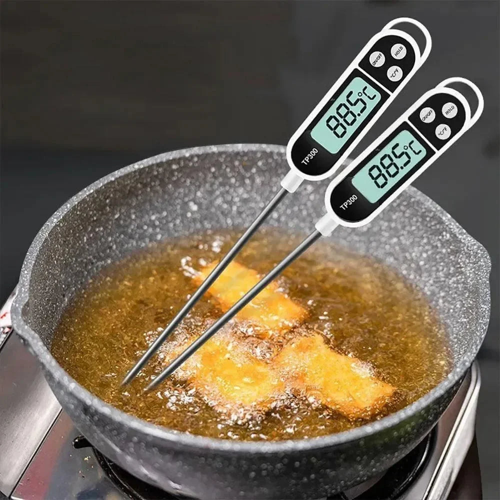 Two digital thermometers showing 88.5°C temperature, inserted into frying food in a pan.