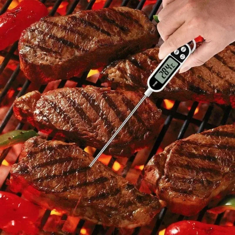 Grilled steaks on a barbecue with a digital thermometer inserted into one of them.