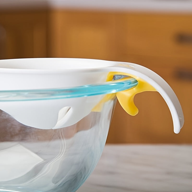 Clear glass bowl with a white lid and yellow sealing strip on a wooden surface.
