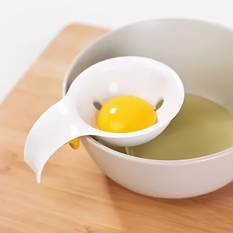 White egg separator with a cracked egg yolk over a white bowl on a wooden surface.