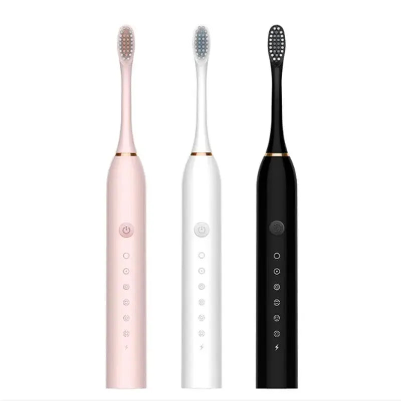 Three electric toothbrushes in pink, white, and black on a white background