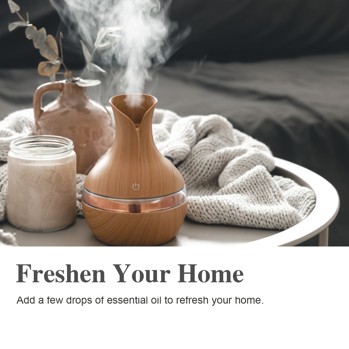 Wooden diffuser emitting steam with a jar of liquid and decorative elements on a table.