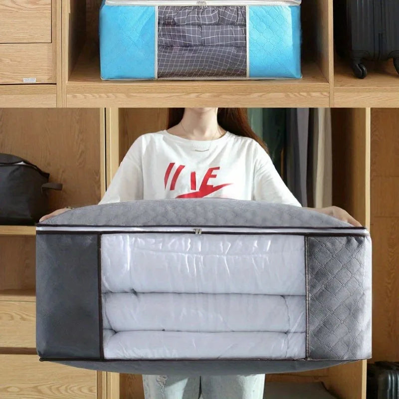 Person holding a large gray packing cube with folded clothes inside, in front of a wooden shelf.