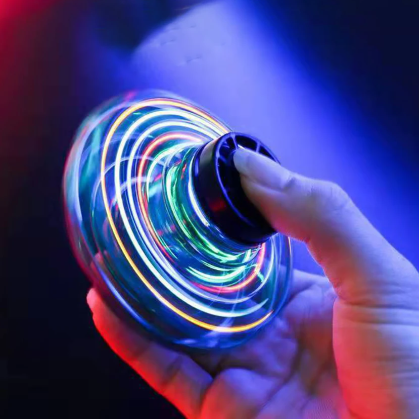 Hand holding a colorful LED spinner against a dark background