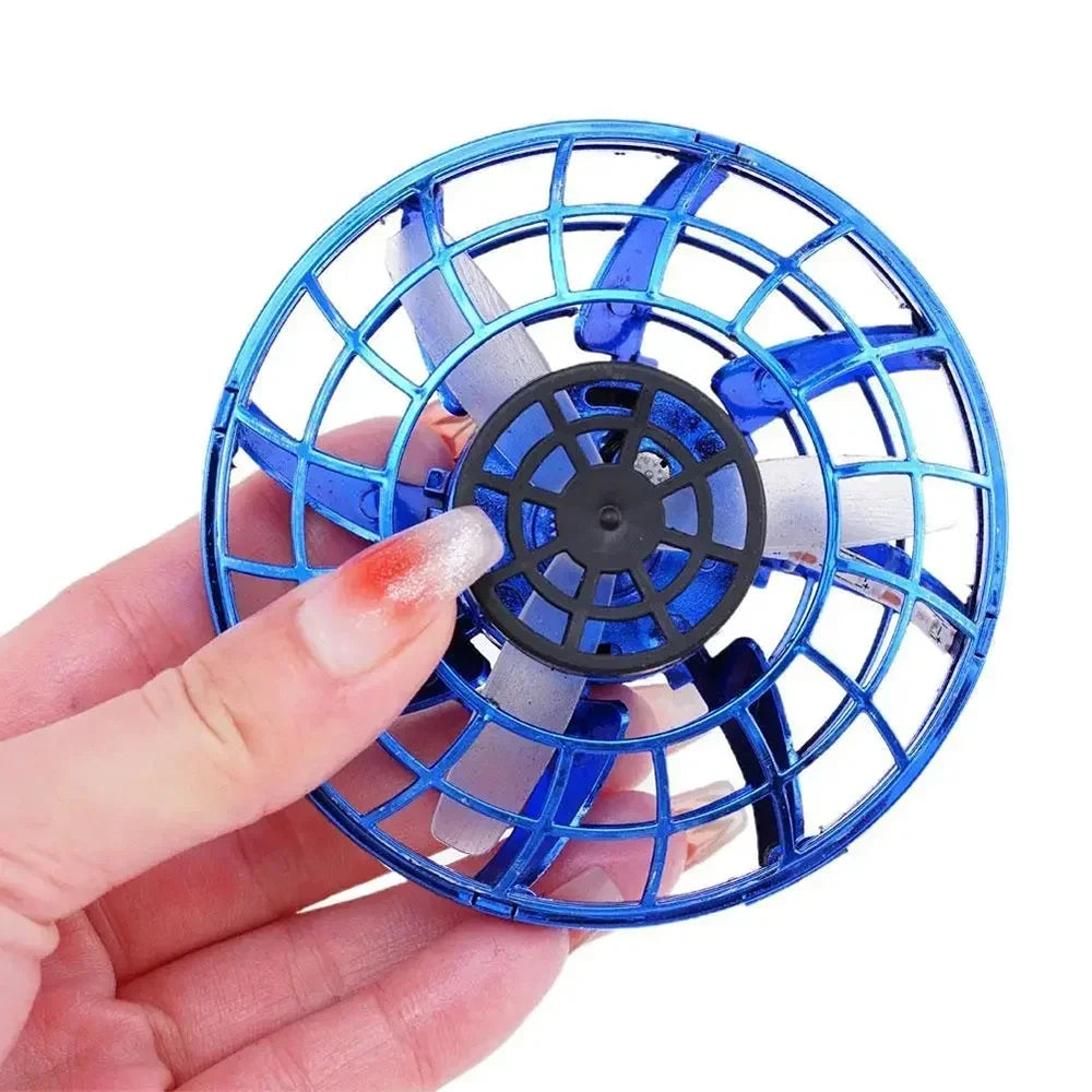 Hand holding a small blue and black fan against a white background