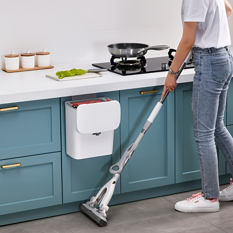 Person using a steam cleaner in a kitchen with teal cabinets and white countertops.