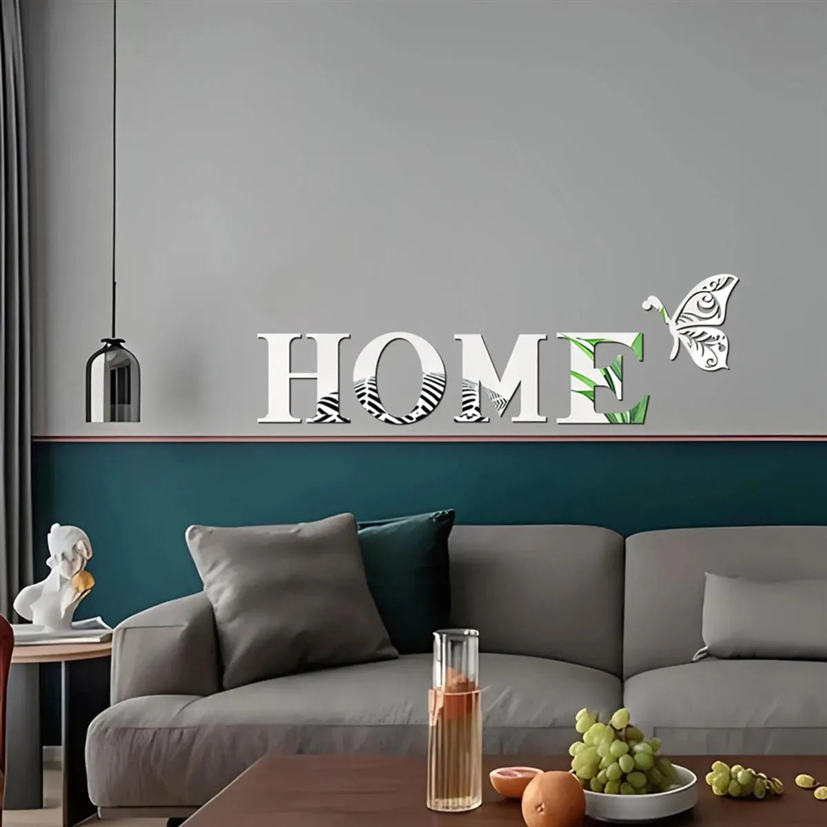 Living room with a gray sofa, decorative pillows, and a 'HOME' wall decal.