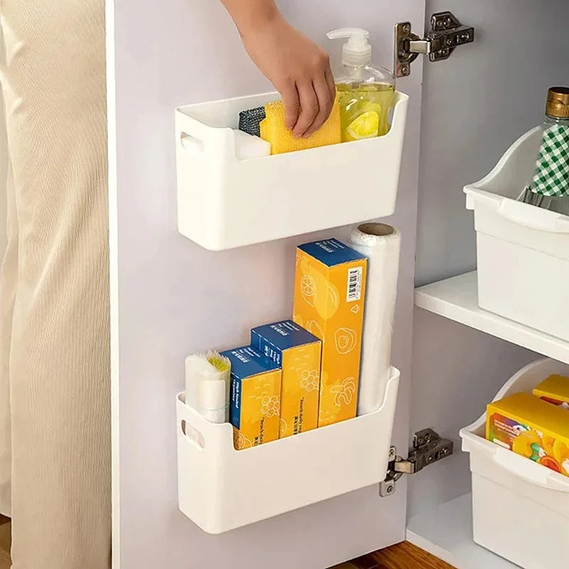 White storage baskets with various items inside a cabinet