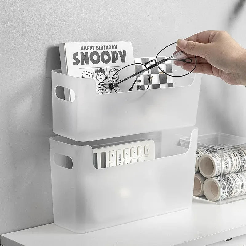 Clear plastic storage bins on a shelf with a hand placing glasses into one of them.