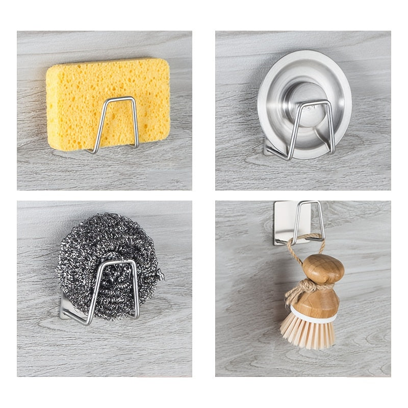Set of four metal wall hooks holding a sponge, scrubber, and other cleaning tools on a wooden surface.