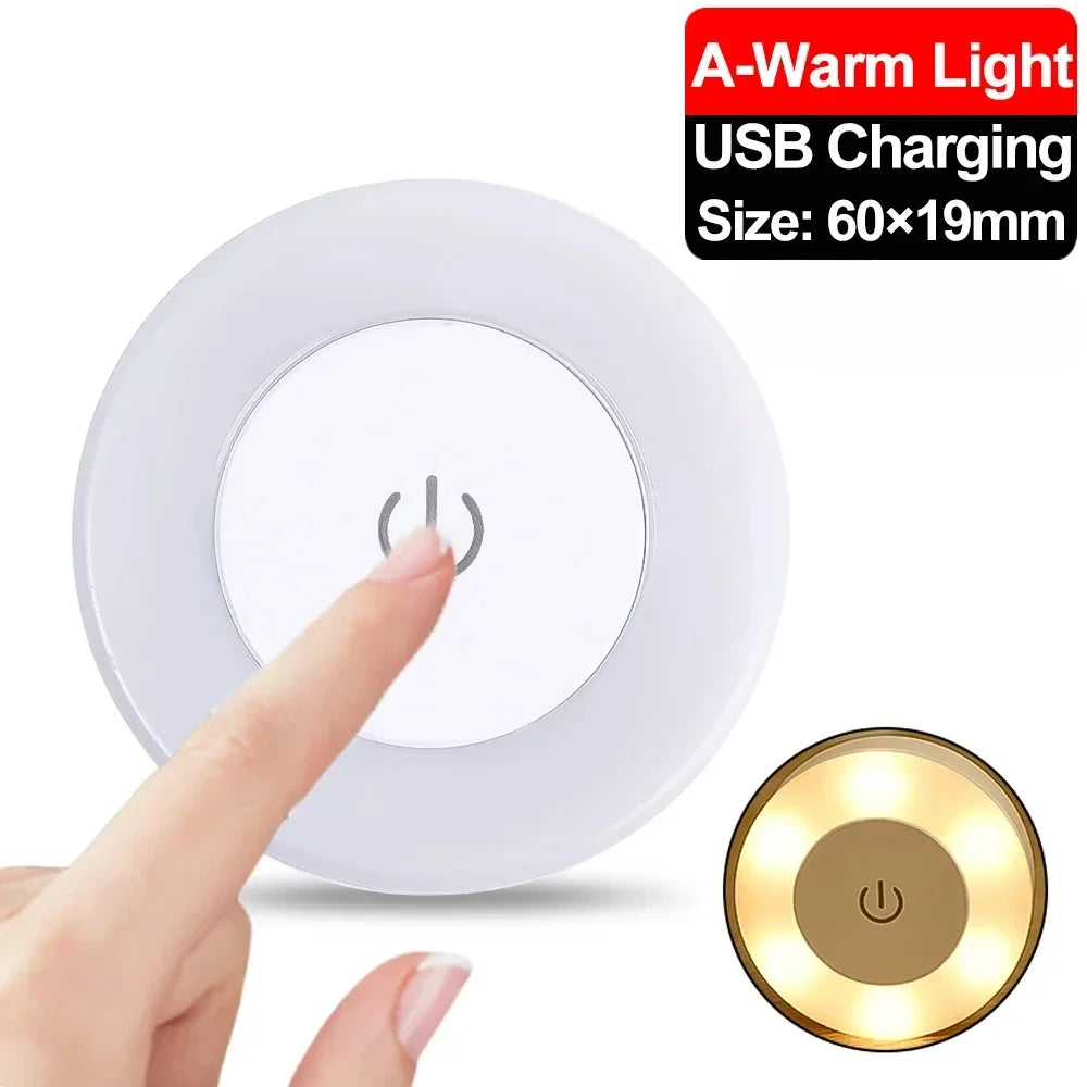 Small round USB charging light with warm light feature, size 60x19mm, being pressed by a finger.