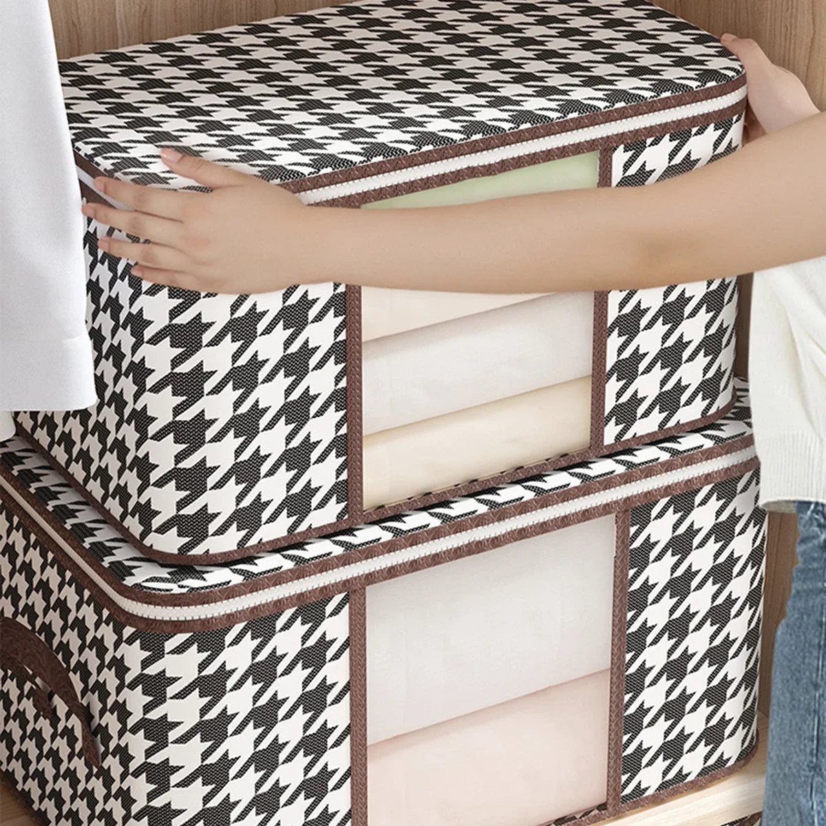 Person holding a black and white patterned storage box