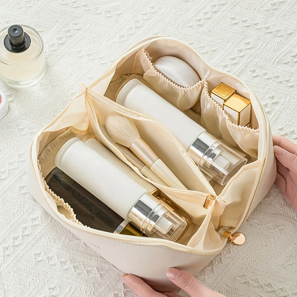 Beige cosmetic bag with various skincare products on a textured white surface