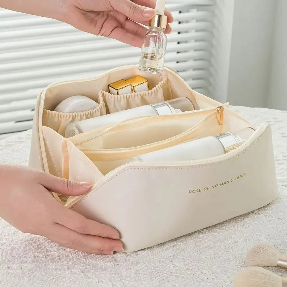 Beige cosmetic bag with skincare products and a hand holding a dropper bottle.