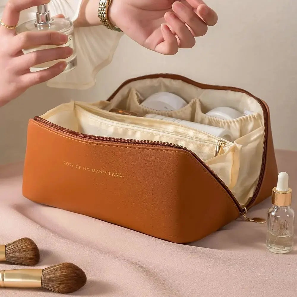 Brown cosmetic bag with makeup items on a beige background