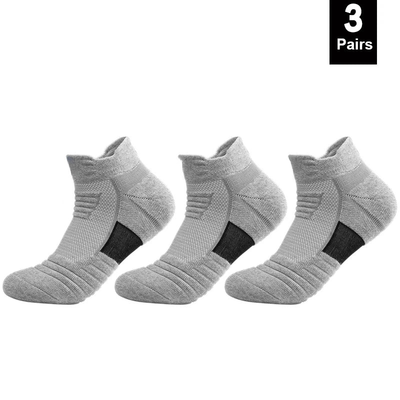 Three pairs of gray ankle socks with black accents on a white background