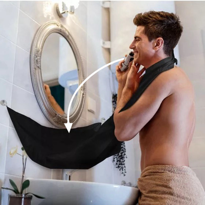 Man using a black towel to shield his chest in front of a mirror.