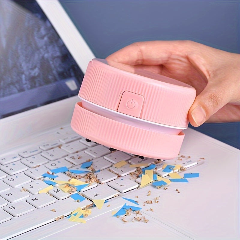 Pink hand held computer cleaner being used on a laptop keyboard with debris.