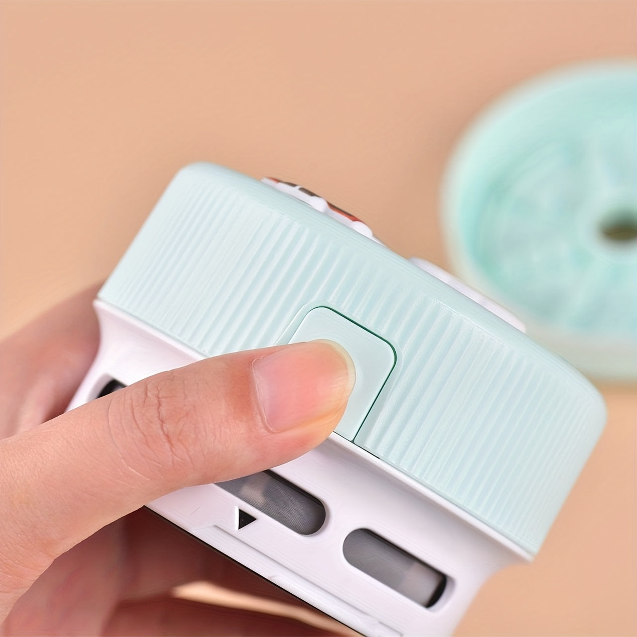 Hand pressing a light blue switch on a beige background