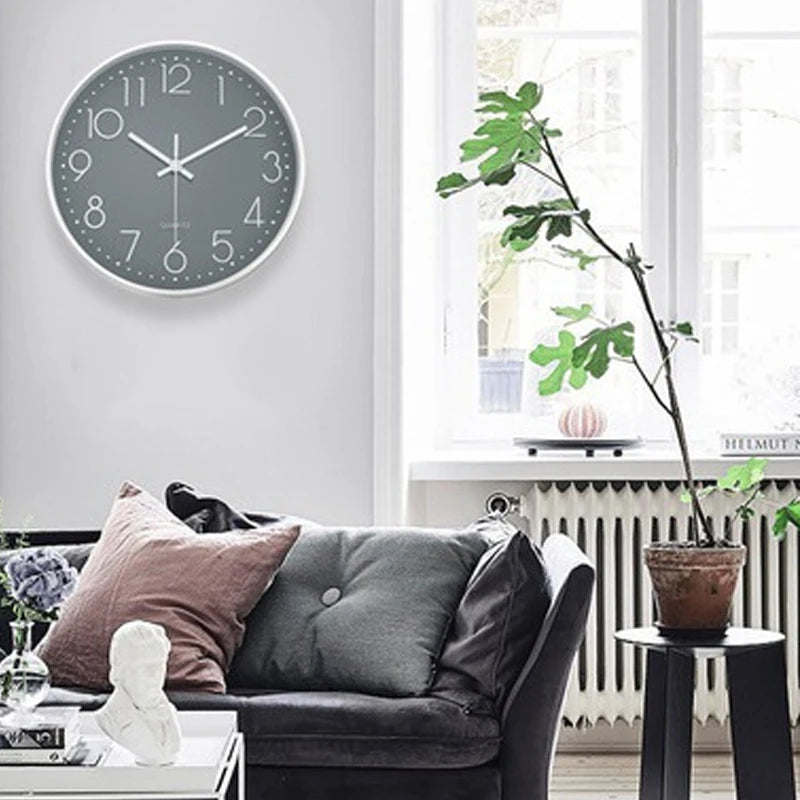 Living room with a grey wall clock, sofa, and decorative items.