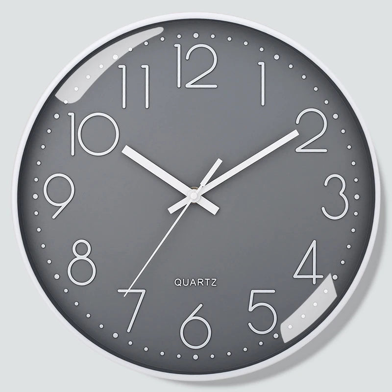 Grey wall clock with white numbers and hands on a light grey background