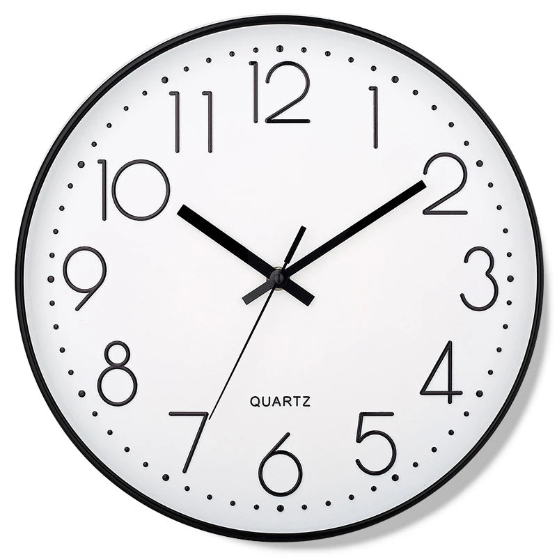 Round wall clock with black frame and white face displaying the time.