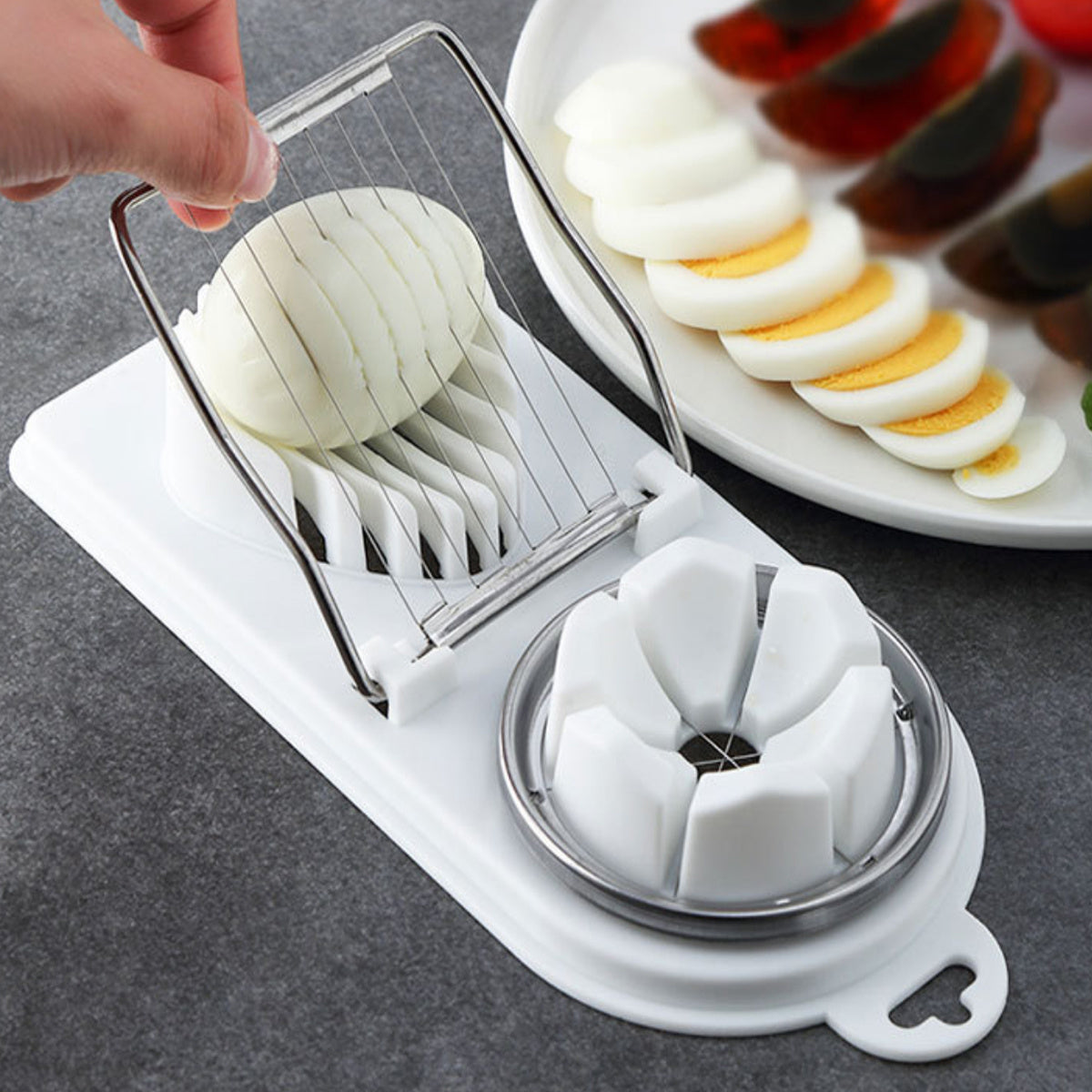 Egg slicer with sliced eggs on a gray surface