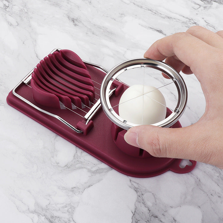 Egg slicer with a hand holding an egg on a marble background