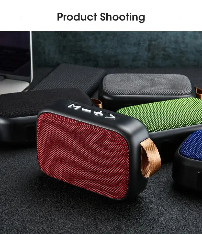 Red portable speaker with a brown strap on a dark surface