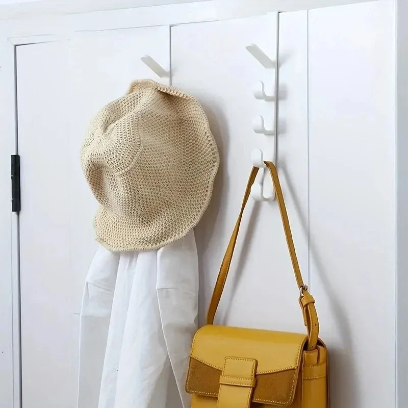 Beige hat and yellow handbag hanging on a white wall with hooks