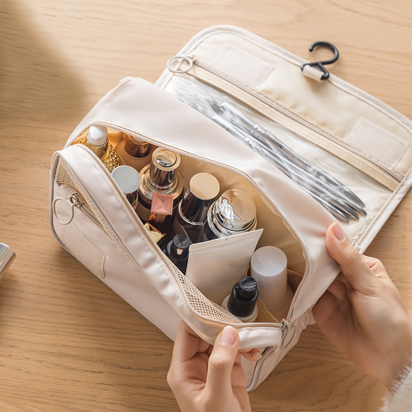 Beige toiletry bag with cosmetic items on a wooden surface