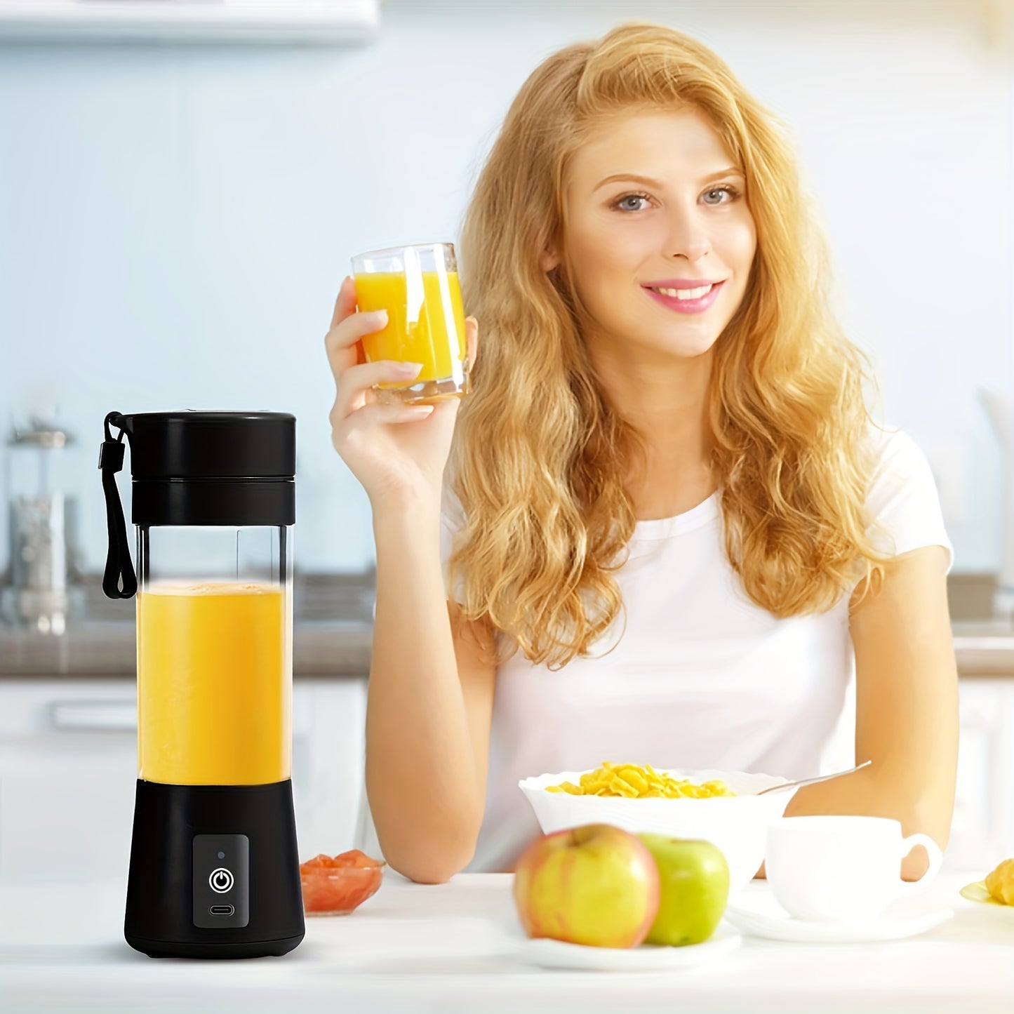 Woman holding a glass of orange juice next to a portable blender with orange juice inside, in a kitchen setting.