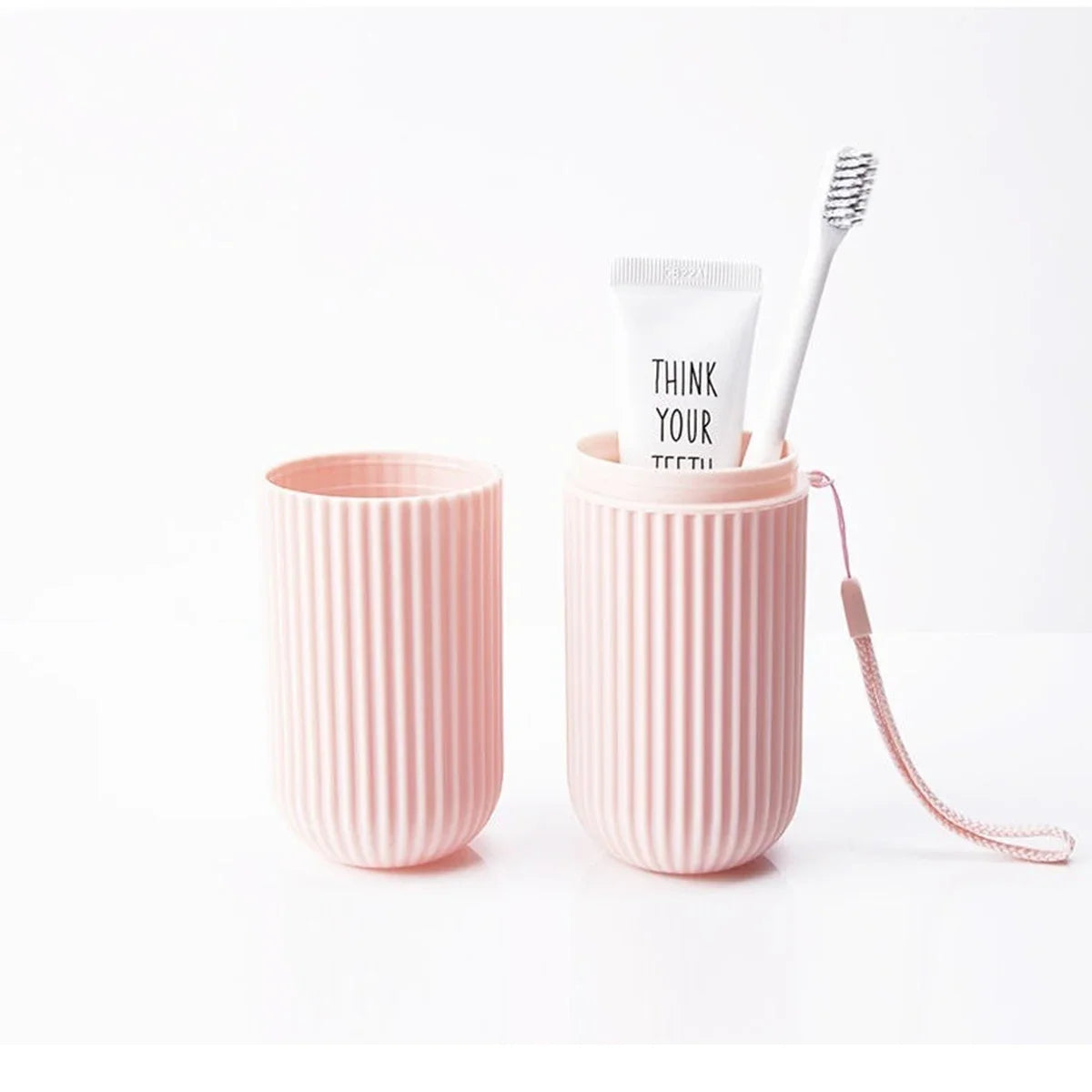 Two pink textured cups with a tube of toothpaste and a toothbrush on a white background